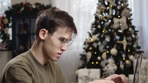 A young man talks by video link at home during the Christmas holidays. The Stock Footage 257385108