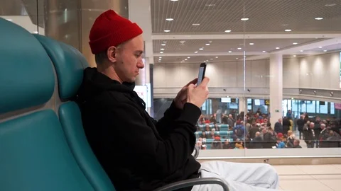 The young man is tapping number on mobile phone standing next to the information Stock Footage 112143099