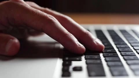 A young man taps his finger on a laptop keyboard trying to come up with an idea. Stock Footage 245360436