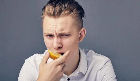 Young man tasting lemon. Stock Photos