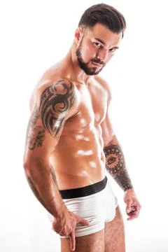 Young man with tattooed torso posing in underwear. Stock Photos