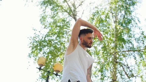 Young man with tattoos performing locking dancing in the park Stock Footage 112161387