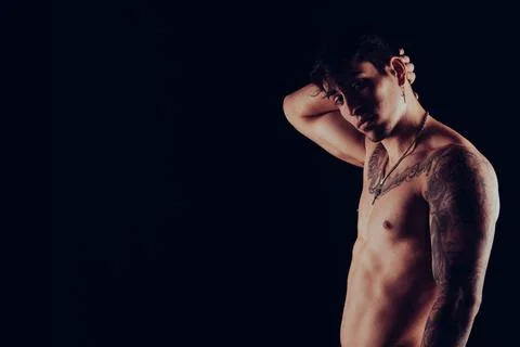 Young man with tattoos posing while facing the camera Stock Photos