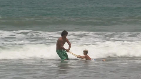 Young man teaching boy to surf Stock Footage 931447