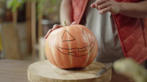 A young man is teaching how carving a halloween pumpkin Stock Footage 170405323