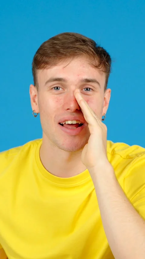 Young man telling a secret to camera Stock Footage 254458282