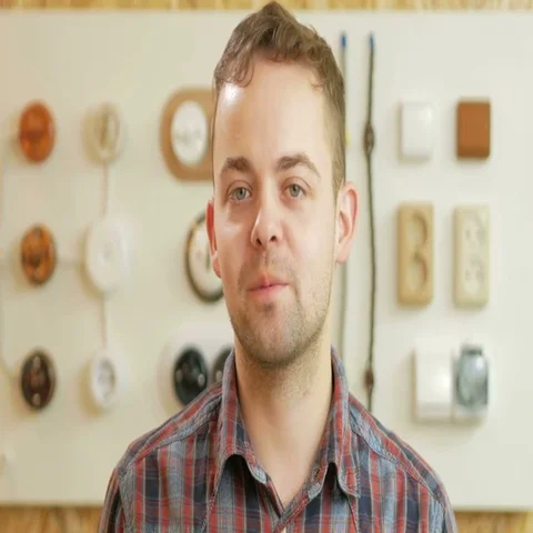 A young man tells the switch sockets and wires of different colors and shapes Stock Footage 69422748