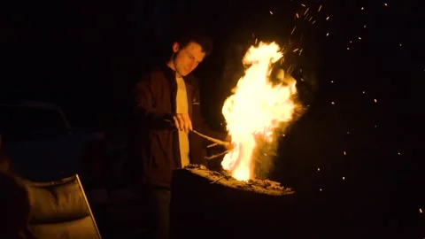 Young Man Tending to Fire Stock Footage 271296730
