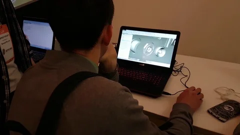 Young man is testing the pc software for modeling space satellites on laptop Stock Footage 73438436