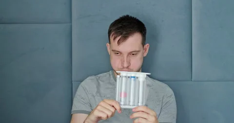 A young man tests his lungs using a spirometer. Stock Footage 278031012