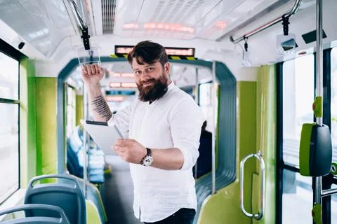 Young man text messaging on tablet in bus Stock Photos