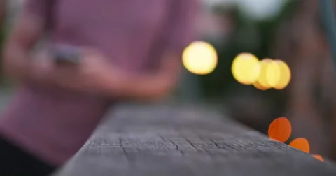 Young Man Texting and Leaning on Bridge with City Lights Dusk, 4K Stock Footage 65139462