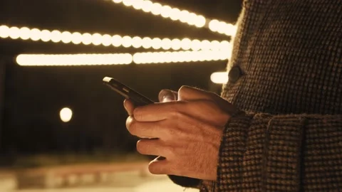 Young man texting chatting on smart phone at night; men finger tapping keypad Stock Footage 155985253