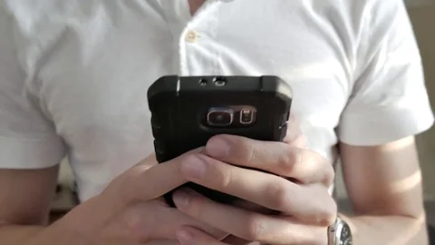 A young man texting on his smart phone 스톡 동영상 75486714