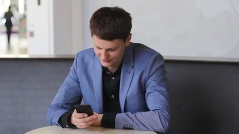 Young man texting on a mobile device Stock Footage 73965877