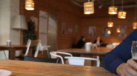 Young man texting on smartphone and drinking beer in cafe Stock Footage 67861406