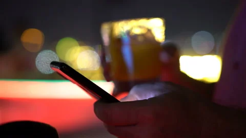 Young man texting on smartphone and drinking cocktail at the bar Stock Footage 108771256