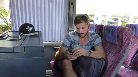 Young man texting on a smartphone in a bus Stock Footage 84988969