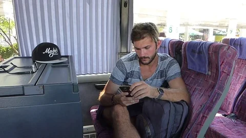 Young man texting on a smartphone in a bus Stock Footage 85072181