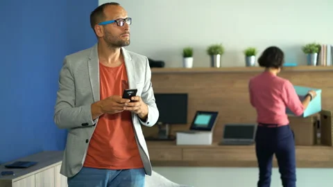 Young man texting on smartphone at modern startup office Video stock 104964044