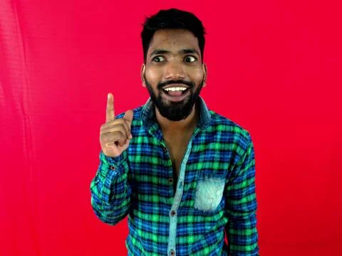 Young man thinking got an idea very excited and happy against red background Stock Photos