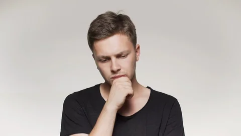 Young man thinking at something with hand on chin. Isolated background Stock Footage 110788166