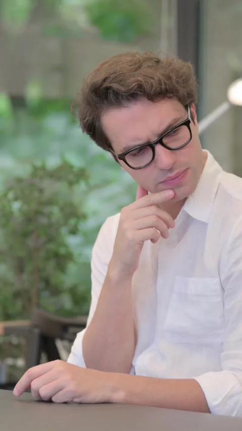 Young Man Thinking while Sitting in Office, Vertical Video Stock Footage 340032793