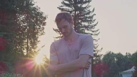 A young man thinks against the background of the sun at sunset.Red Helium 8K Stock-Footage 156278988