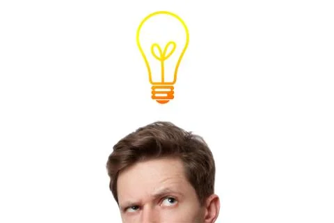 Young man with thoughtful expression and light bulb over his head Stock Photos