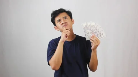 Young man thoughtfully considering financial Video stock 318453658