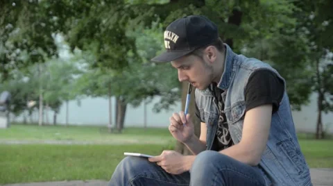 A young man thoughtfully records in a notebook. Stock Footage 51754870
