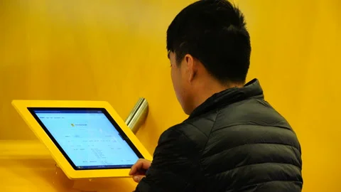 A young man thoughtfully scrolls through the information on an electronic device Stock Footage 93677747
