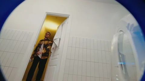 Young man throwing clothes in washing machine 스톡 동영상 172582416