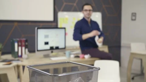 Young man throwing papers into trash basket Stock Footage 72567539