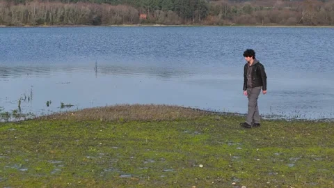 Young Man Throwing Rocks To The Lake - Drone Shot Stock Footage 269911250