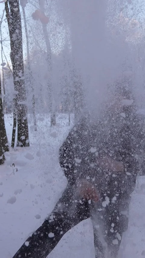 Young man throwing snow up in the air in a winter forest Vidéo 331721768