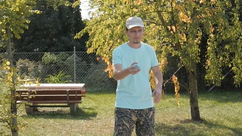 Young Man throws Balls playing Petanque in a Park Stock Footage 95319518