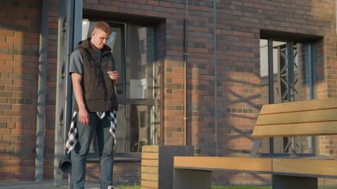 Young man throws cigarette into waste bin outdoors during daylight Video stock 307067477