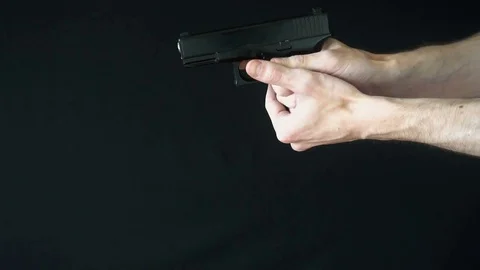 The young man throws the empty clip from the pistol Stock Footage 77063836