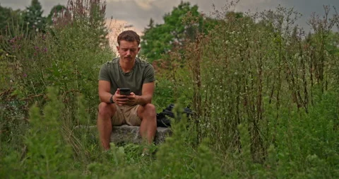 Young man throws his phone into his bag in frustration after bad news 스톡 동영상 321322086