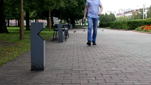 A young man throws a plastic bottle in the city near a trash can Stockbeeldmateriaal 95231431