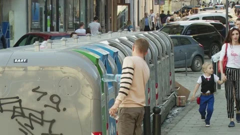 Young man throws a plastic bottle into a trash can. containers with garbage. Stock Footage 132252544