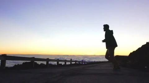 Young Man Throws Rock Off Mountain Top Volcanic Crater. Freedom Success Achie Stock Footage 58884222