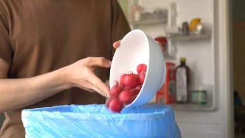 Young man throws spoiled vegetables out of the fridge Stock Footage 106194933