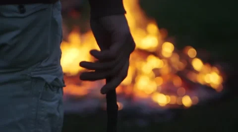 Young Man Throws Stick into a Bonfire Stock Footage 48690187