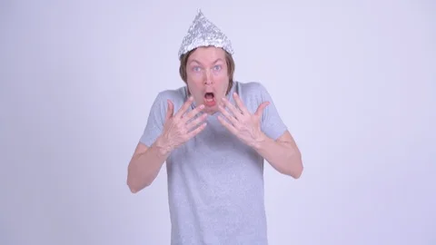 Young man with tinfoil hat looking shocked 動画素材 118653843