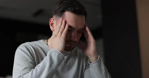 Young man tired with hands on face physical and emotional discomfort Stock Footage 302262231
