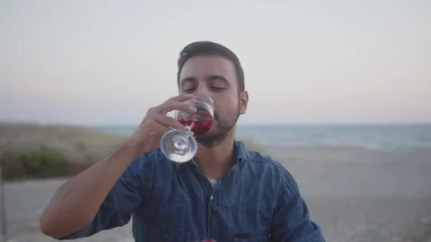 Young man toasting with wine looking at camera smiling outdoors Stock Footage 270248522