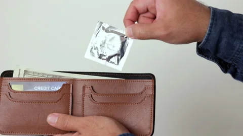 The young man took out a condom from his wallet, ready to use anytime anywhere.  Stock Footage 161235316