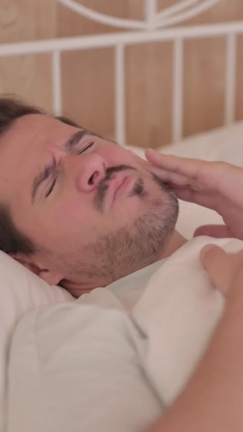 Young Man with Toothache while Lying in Bed, vertical video Video stock 328564966